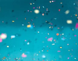 Many confetti flying in the air on a blue background