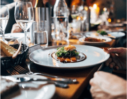 A dish in a restaurant with many utensils around